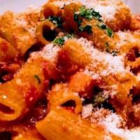 Rigatoni All'Amatriciana · Spicy. Homemade rigatoni, tomato sauce, pancetta, onions, red pepper flakes, parmigiano chee...