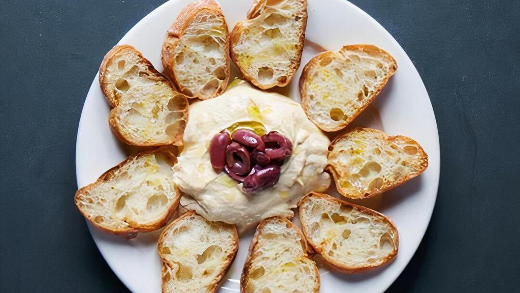 Hummus · Creamy puréed chickpeas with tahini, lemon juice and garlic, served with grilled ciabatta and kalamata olives