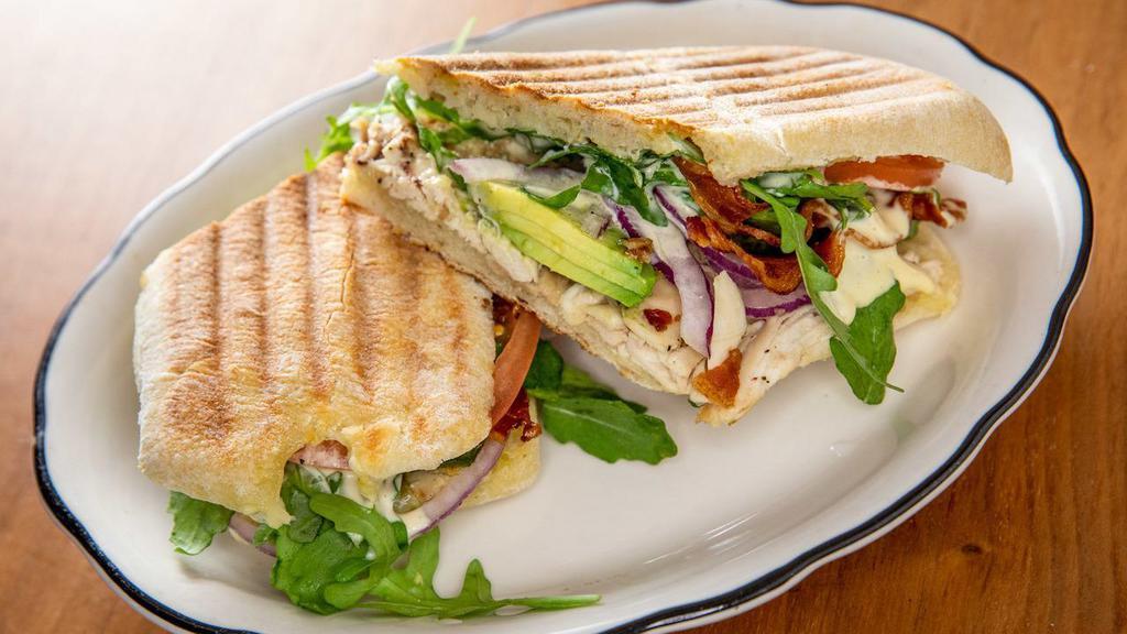 Chicken Panini · Swiss cheese, bacon, avocados, red onions, arugula, tomatoes, with French mustard vinaigrette.