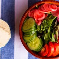 Jerusalem Salad · Artisanal hummus, pickled red onions, radishes, tomatoes, and cucumber on a bed of mesclun w...