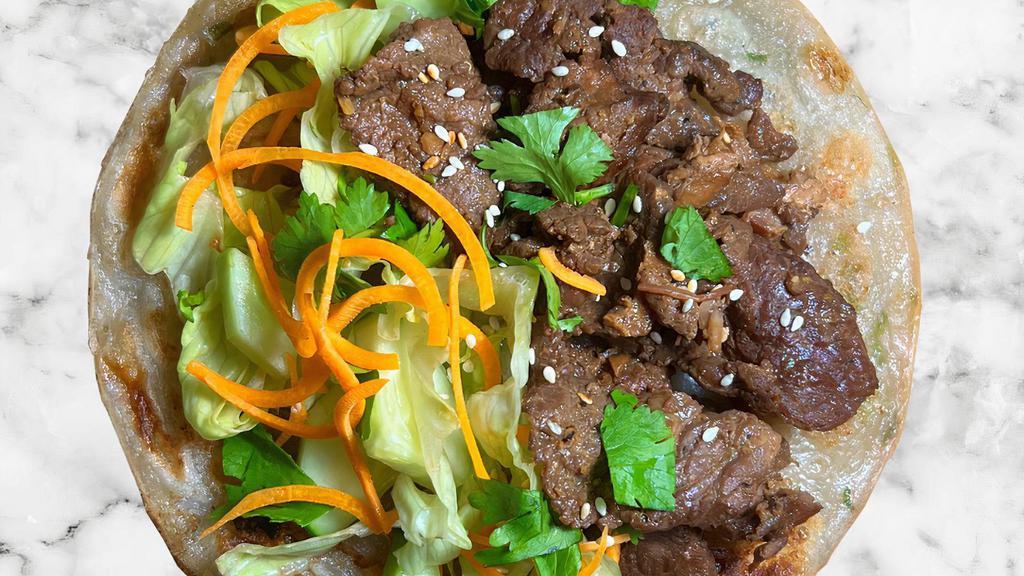 Beef Scallion Pancake Wrap  · Our signature flaky, crispy scallion pancake filled with tender prime beef, sautéed onions, pickled carrots, fresh cucumbers, lettuce, and sesame seed. Your choice of sauce on the side.