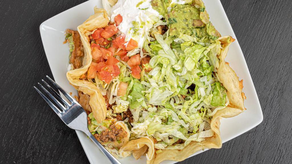 Taco Salad · Served in a crispy flour tortilla bowl with refried beans, lettuce, sour cream, shredded cheese, guacamole, and tomato. Your choice of meat.
