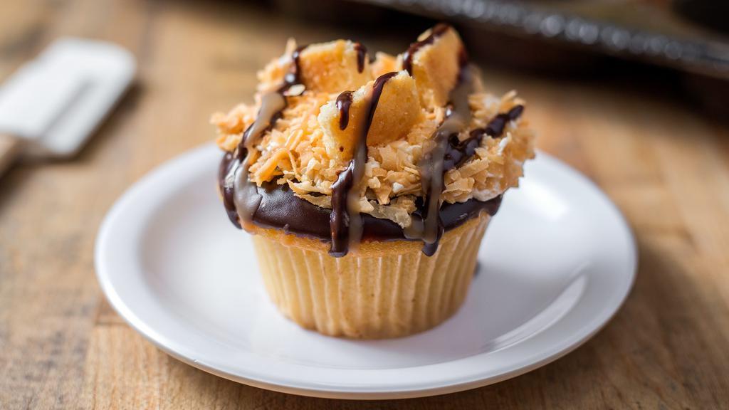 Samoa · vanilla cake filled with caramel, topped with buttercream, toasted coconut, chocolate and caramel drizzle and a shortbread cookie