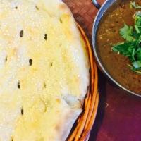 Mutton Curry With Naan · Goat cooked in traditional curry with onions and tomatoes.