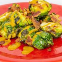 Brussels Sprouts · Crispy Brussels sprouts topped with crumbled bacon and Crispy's signature sauce.
