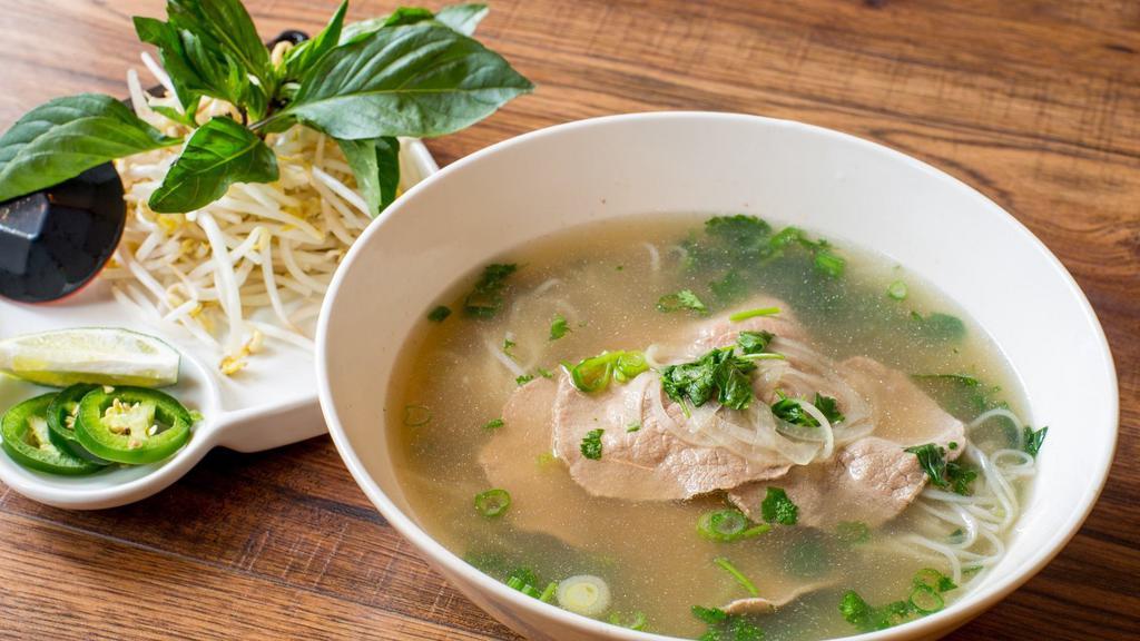 Phở Tái · Traditional pho with beef eye round. Beef broth and rice noodles. Topped with scallion, onion and cilantro. Served with bean sprout, jalapeno, basil, and lime or lemon.