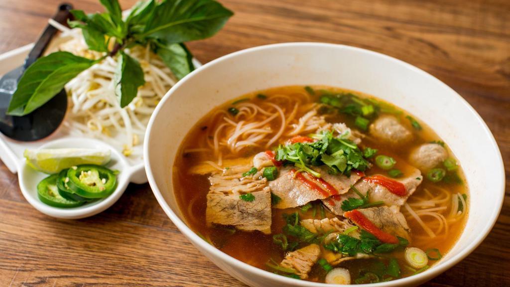 Spicy Phở · Hot and spicy. Beef eye round, brisket, omasum, tendon, and beef meatballs. Beef broth and rice noodle. Topped with scallion, onion and cilantro. Served with bean sprout, jalapeno, basil, and lime or lemon. Hot and spicy.