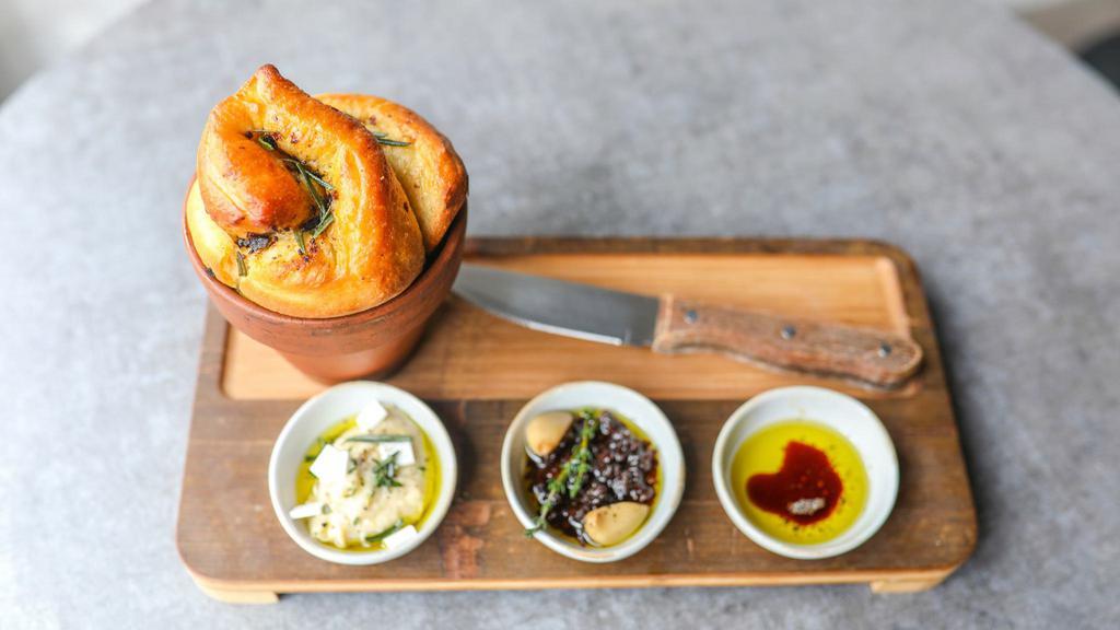 Olive And Rosemary Bread · Served in a flower pot with a dip trio: Evoo, aged balsamic and cracked pepper, Sundried tomato and garlic confit, Sunchoke and herb feta.