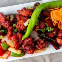 Chicken 65 · Stir fried chicken cubes tossed with spring onions, lemon leaves, ginger, cilantro and musta...