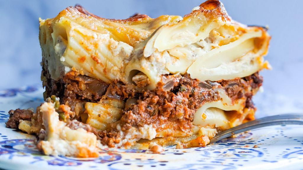 Macarona Bashamil · Baked pasta layered with ground beef in béchamel sauce.