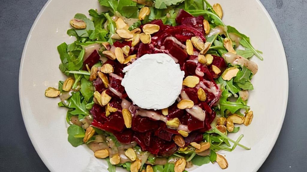 Beet And Goat Cheese Salad · Roasted beet salad with goat cheese, crushed pistachios, orange zest and pickled red onions and arugula with a garlic balsamic vinaigrette dressing