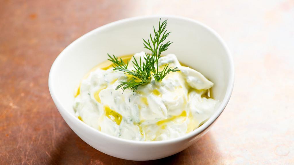 Tzatziki Dip · Greek yogurt, garlic, cucumbers, and dill. Served with baked pita chips.