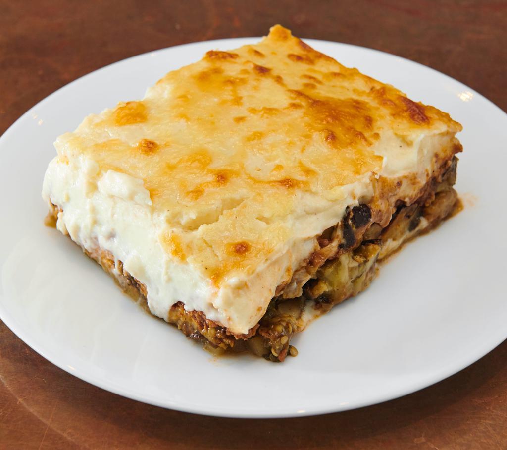 Moussaka Pi · Baked eggplant, ground beef and potatoes in a caramelized tomato sauce, topped with a light béchamel sauce and kasseri cheese.