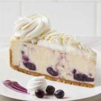 Blueberries And Cream Cheesecake · Creamy white chocolate cheesecake swirled with wild blueberries and white chocolate on a gra...
