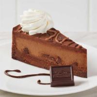 Triple Chocolate Ghirardelli® Cheesecake · Rich chocolate cheesecake with chocolate chips, baked on a moist brownie and topped with cho...