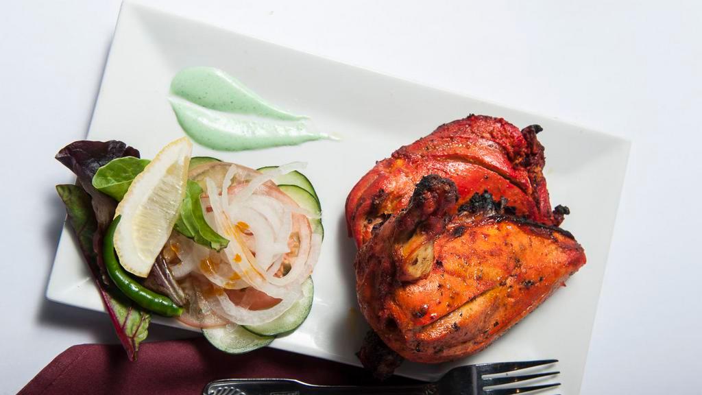 Tandoori Chicken · Spring chicken marinated in yogurt, garlic, ginger, lemon and fresh ground spices overnight and roasted to perfection in a clay oven.