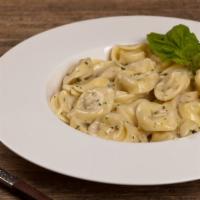 Tortellini Alfredo · Fresh tortellini alfredo with roasted peppers and peas topped with parmesan cheese.