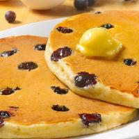 Wild Blueberry Sweet Cakes · Pancakes Perfected: Two platter-sized, thick and fluffy pancakes, topped with sweetness and ...