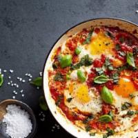 Shakshuka · Three eggs baked with tomato, onions, peppers, spices, tahini.