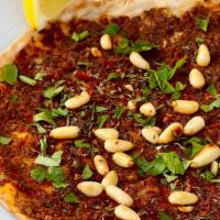 Lahm Bi Ajin · Traditional meat flatbread with pine nuts, house-made herby harissa and pomegranate vinaigre...