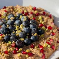 Chocolate Tahini Overnight Oats · Topped with pistachio and fresh berries. Vegan & Gluten Free. Contains Nuts.