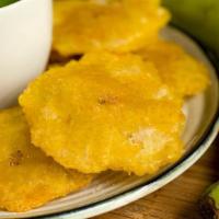 Tostones · Dominican style green plantains, flattened and fried to golden medallions, lightly sprinkled...