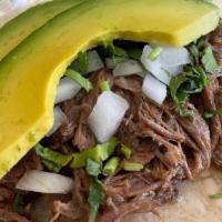 Slow Cooked Beef Barbacoa Taco · Shredded beef, fresh onions, cilantro and sliced Mexican avocado. Paired with a side of aji ...