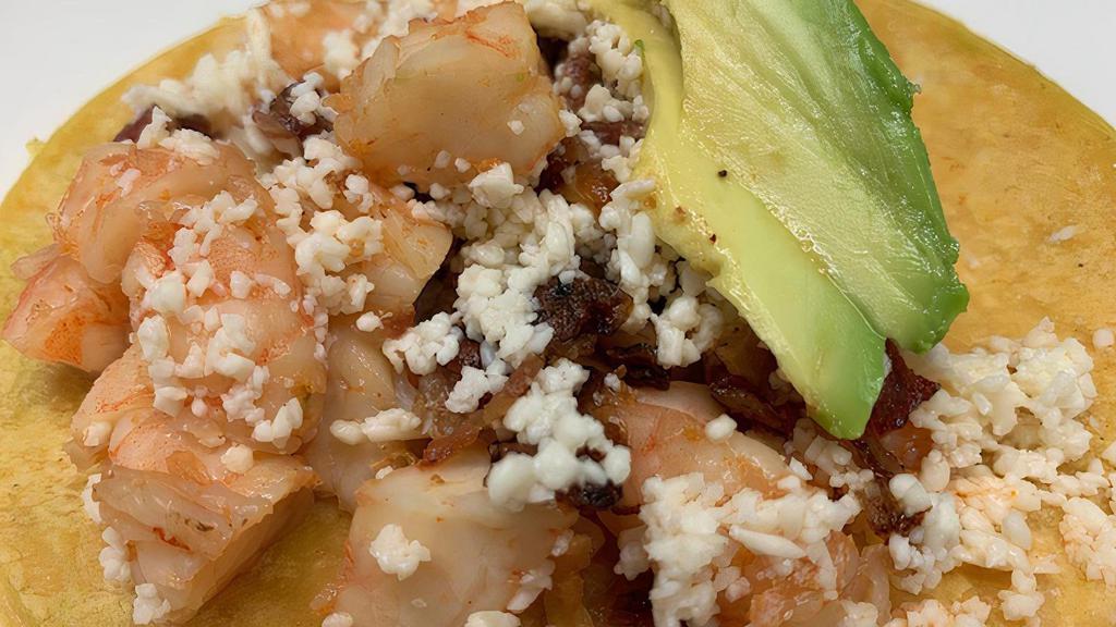 Chipotle Glazed Shrimp Taco · Chipotle and garlic glazed shrimp, queso fresco, diced apple wood bacon and sliced Mexican avocado. Paired with a side of crema. Gluten free.