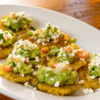 Tostones A La Mexicana · Fresh green plantain topped with fresh guacamole, pico de gallo, and sprinkles of cheese.
