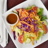 Thai House Salad · A colorful assembly of lettuce, tomato, cucumber, and carrot, served with Thai house peanut ...