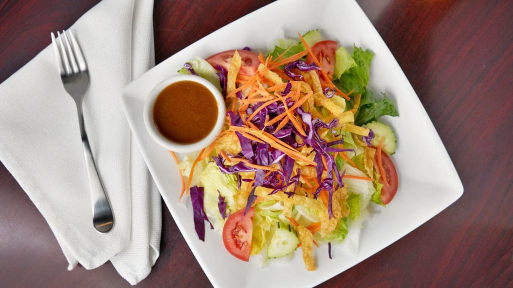 Thai House Salad · A colorful assembly of lettuce, tomato, cucumber, and carrot, served with Thai house peanut dressing.