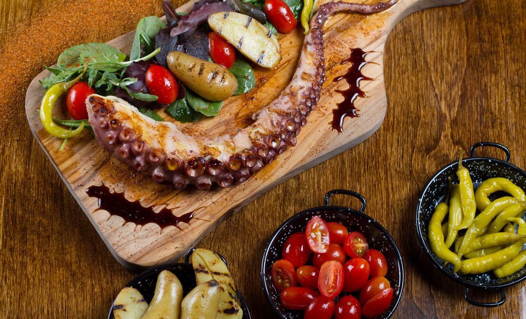 Pulpo A La Plancha · Grilled octopus served with potato, arugula, and cherry peppers.