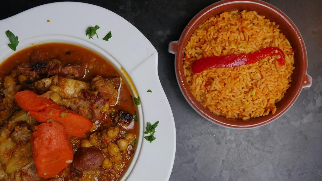 Cocido Madrileño · Chickpea based stew with pork, chorizo, carrot, and Spanish potato. Served with a side of yellow rice.