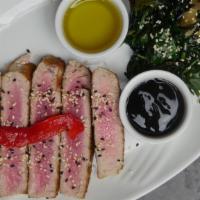 Tuna Steak · Sesame seed pan-seared tuna with a spinach salad topped with balsamic glaze.