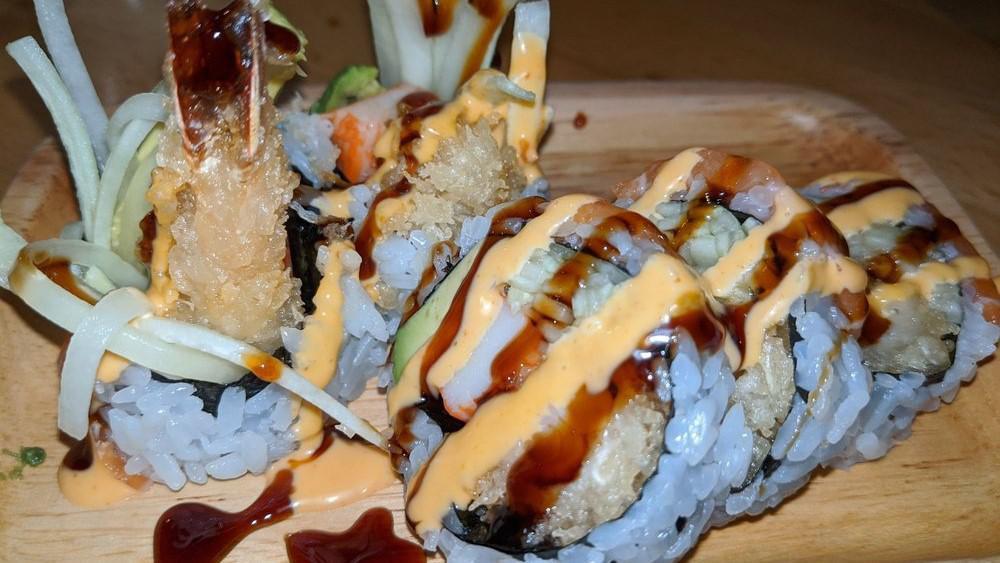 Tiger Roll · Inside shrimp tempura, kani, avocado, and cucumber topped with salmon, eel sauce, and spicy mayonnaise.