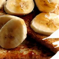Banana French Toast · Four slices of egg-washed French toast topped with banana, whipped cream, maple syrup and bu...