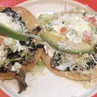 Tostada Con Bistec / Steak Tostada · Tortilla plana con carne, frijoles, lechuga, tomate, queso y crema agria. / Flat tortilla sh...