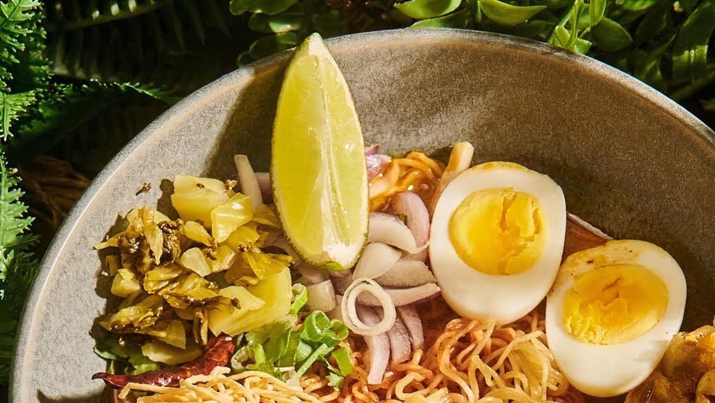 Khao Soy Chicken · Spicy. Northern Thai style egg noodles in a rich chicken curry broth, red onion, pickled mustard, boiled egg, crispy egg noodles.