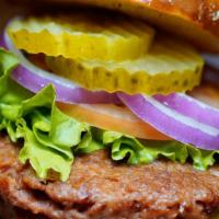 The Plant Based Burger · Plant based burger topped with lettuce, tomatoes, onions, pickles and ketchup on a toasted b...