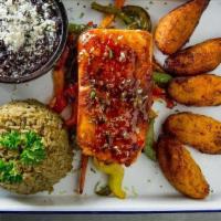 El Norteno (Salmon) · Pan Seared 8oz Atlantic Salmon topped with our Guava-Chili sauce and lime zest on a bed of o...