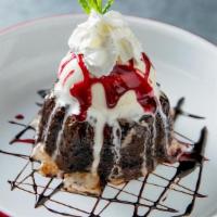 El Volcano · Chocolate Lava cake topped with scoop of vanilla ice cream, raspberry syrup and whipped cream