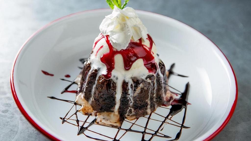 El Volcano · Chocolate Lava cake topped with scoop of vanilla ice cream, raspberry syrup and whipped cream