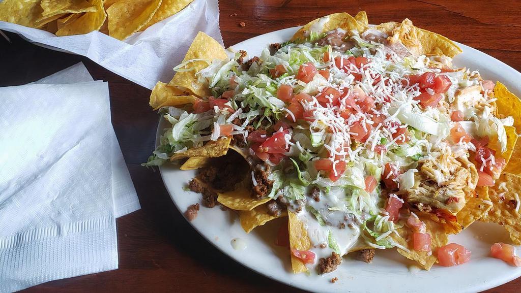 Los Cabos Nachos · Steak, chicken and shrimp a bed of crispy tortilla chips with shrimp, chicken, steak, bell peppers, onions and tomatoes. Covered with cheese dip.