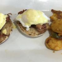 Eggs Benedict · Two poached eggs over an English muffin, topped with hollandaise sauce (served with mixed gr...