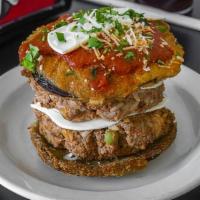 Stuffed Eggplant · Layered fried eggplant towered with chopped meat, rice, melted mozzarella, and tomato sauce
