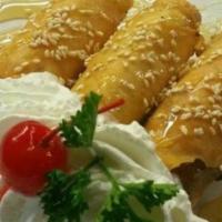 Fried Banana · Banana and cream cheese wrapped and deep fried. Drizzled with honey and topped with whipped ...