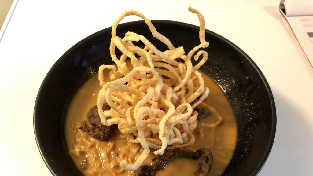 Khao Soy Beef · Egg noodle, red onion, scallion and pickles in spicy northern thai curry. Topped with Crispy Egg Noodle.
