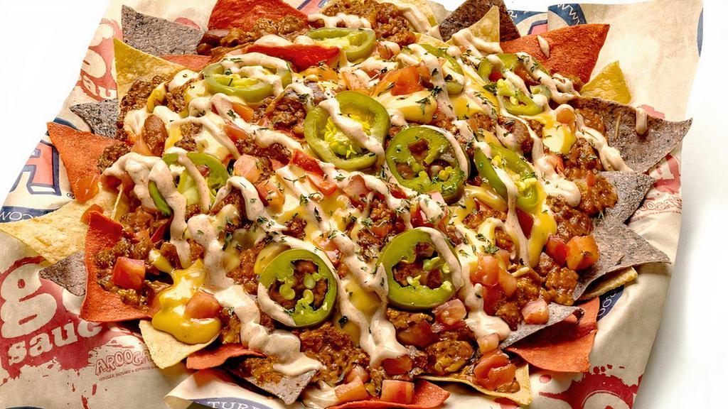 Impossible Nachos · Fresh fried tortilla chips layered with Impossible Chili, Fat Tire beer cheese, & cheddar/mozzarella cheeses, jalapenos, chopped tomatoes, chipotle sour cream