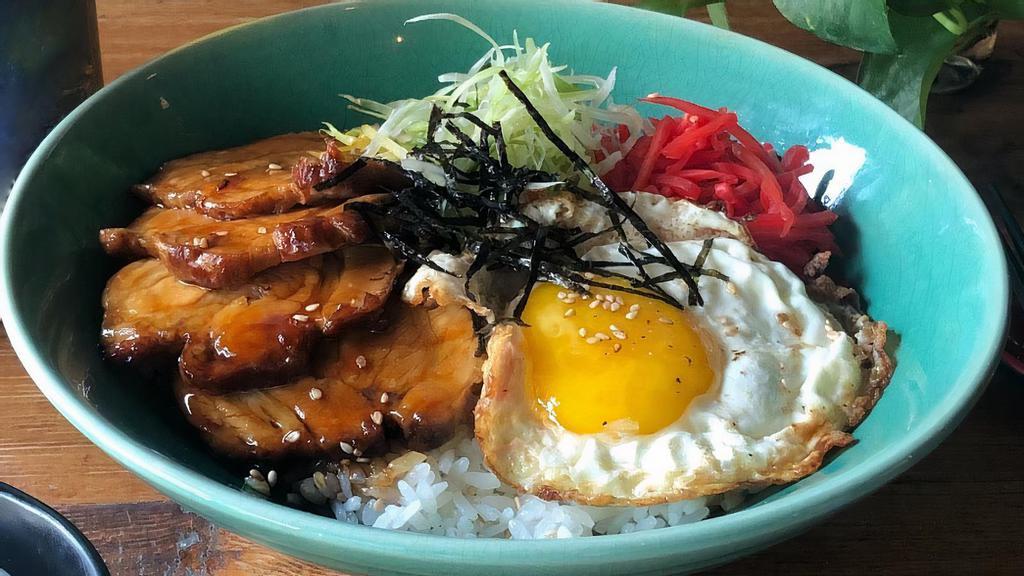 Chashu Don · Braised pork belly served over rice with fried egg, pickled ginger, scallions, sesame seeds, and shredded nori.