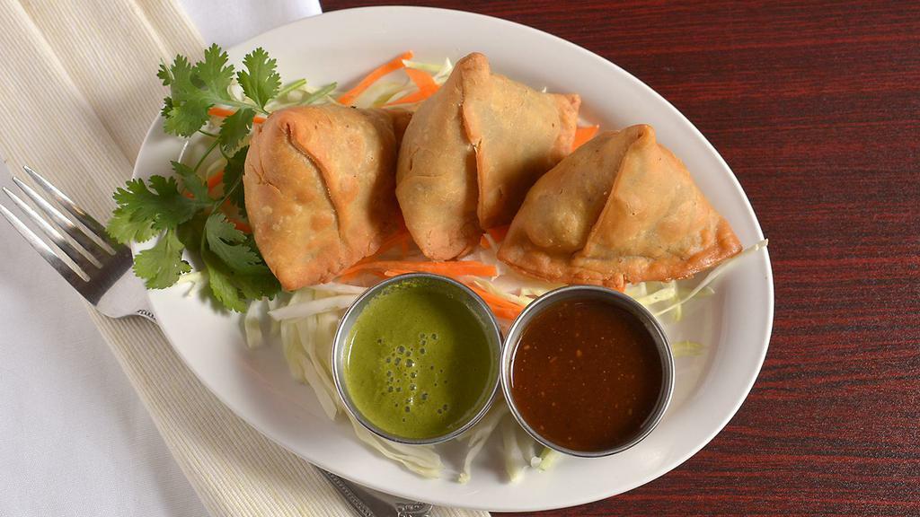 Samosa 2Pc · Triangular turnovers filled with potatoes and green peas, Indian spices, served with mint and tamarind chutney